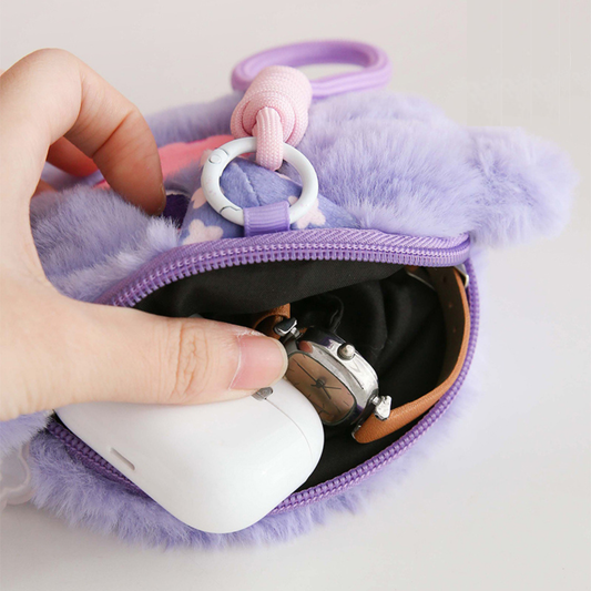 Purple fluffy pouch with a hand holding an AirPods case and keychain.