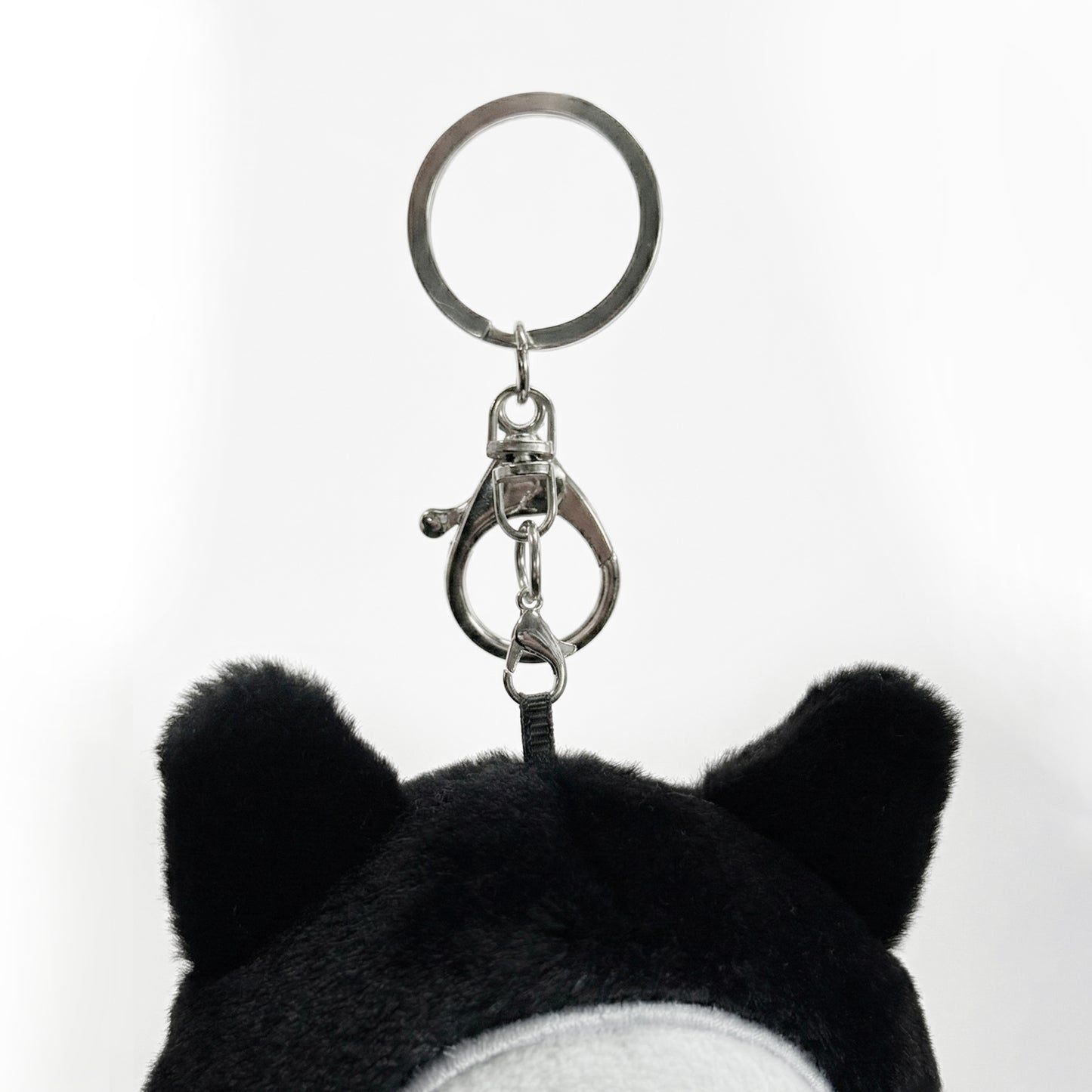 Black and white plush keychain  called Koko the skeleton  with a keyring on a white background